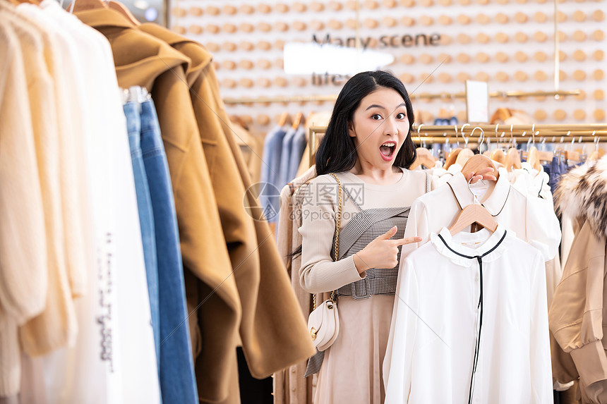 年轻美女商场购物挑选衣服图片