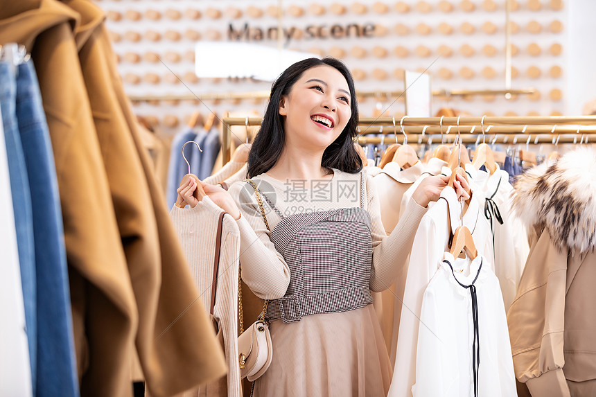 年轻美女商场购物挑选衣服图片