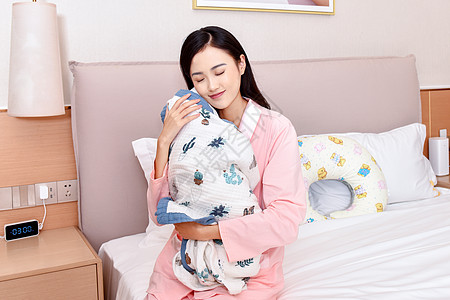 母亲闭眼抱着新生婴儿高清图片