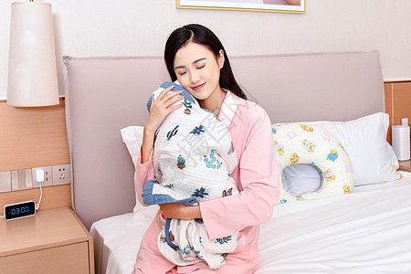 母亲闭眼抱着新生婴儿图片