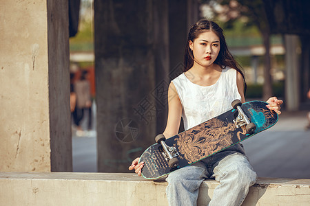 街头模特夕阳下的滑板女孩背景