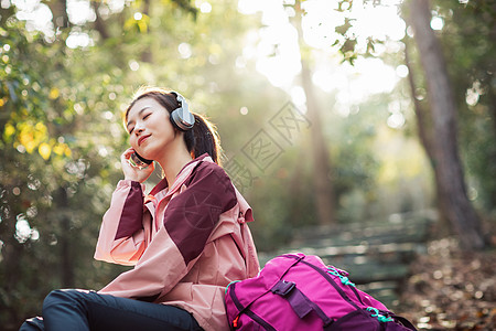 阳光路上女生坐在山间小路上听音乐背景