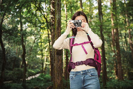 青年女性在森林里拍照图片