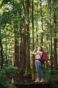 远足青年女性在森林里拍照背景
