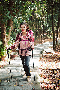 用登山杖爬山的女性形象图片