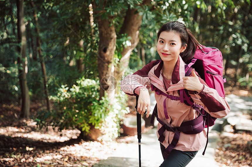 用登山杖爬山的女性形象图片