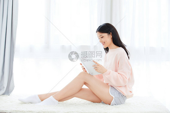 居家美女坐在飘窗看书图片