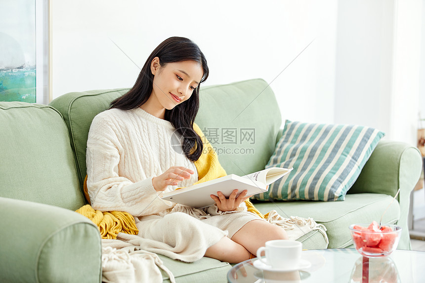 居家美女坐沙发上看书