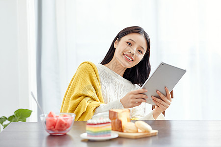 居家美女吃早点玩平板电脑图片