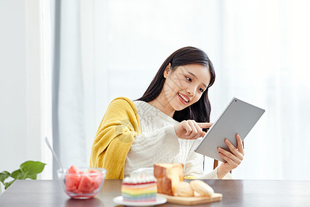 居家美女吃早点玩平板电脑图片