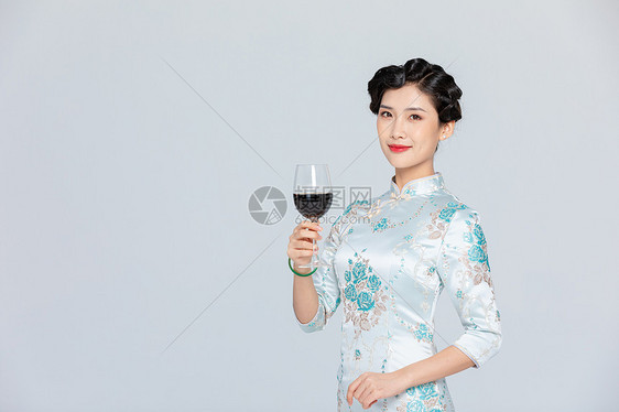 旗袍女性拿红酒图片