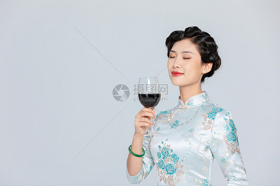 旗袍女性拿红酒图片