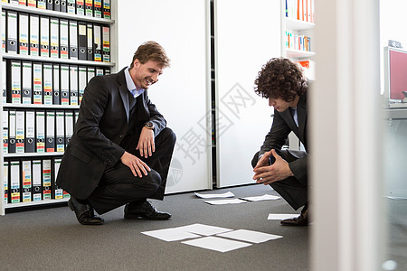 商人在办公室地板上铺设文书图片