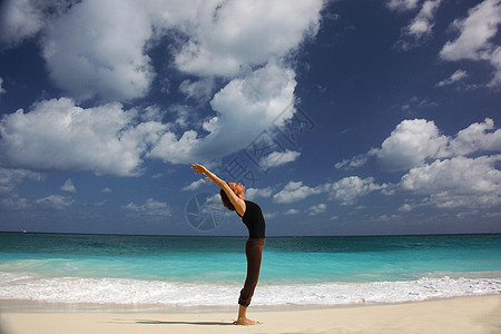 在巴哈马拿骚天堂岛海滩做瑜伽的成熟女性图片