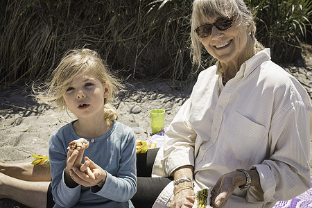 奶奶和孙女在沙滩上野餐图片