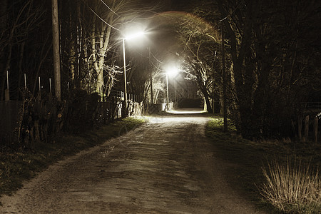 夜间的土车道和路灯背景图片