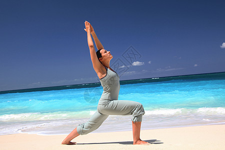 在热带海滩上练习瑜伽的女人背景图片