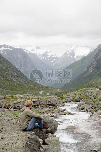 坐在山川边的人图片