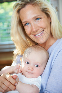 微笑的母亲抱着婴儿图片