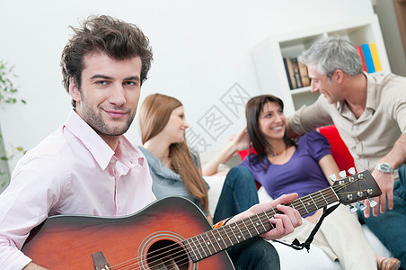 带着吉他和快乐朋友的微笑男人图片
