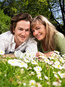 一对躺在草地上微笑的夫妇图片