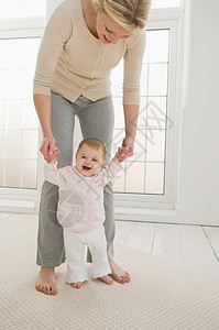 帮助婴儿走路的母亲女婴高清图片素材