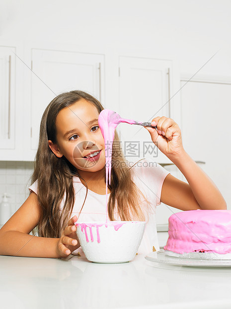 女孩用糖霜装饰蛋糕图片