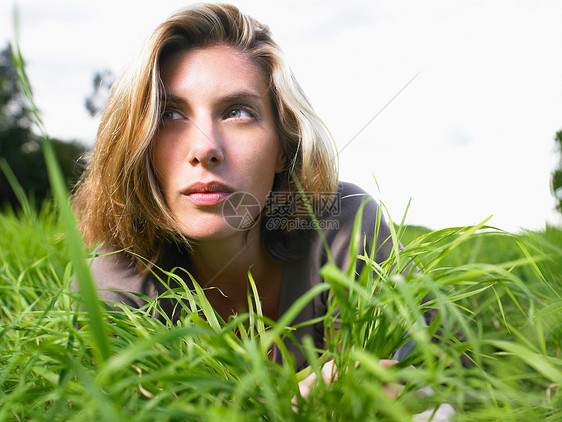 女人躺在绿野中的肖像图片