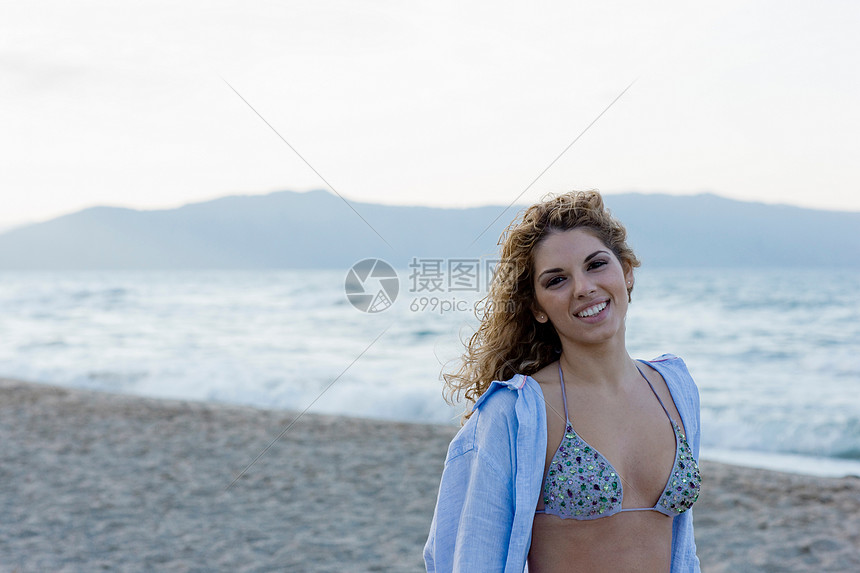 海滩上的女人对着镜头微笑图片