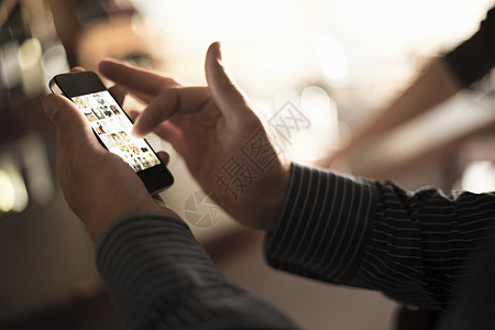 外国商务人士酒吧中使用智能手机触摸屏的男子特写镜头背景