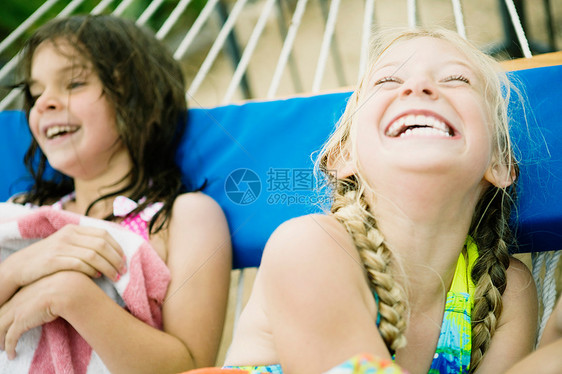 两个年轻女孩在吊床上大笑图片