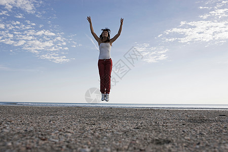 在海滩上跳跃的女人图片