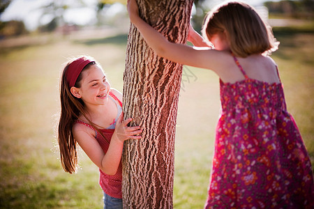 2个小女孩在树上玩耍图片