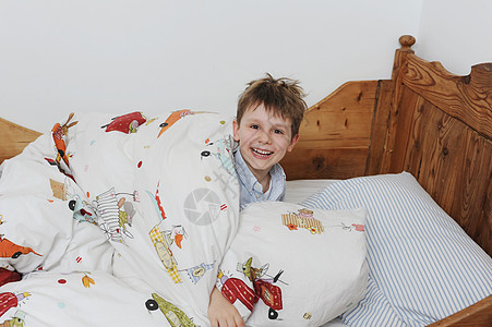 在床上玩耍的男孩图片