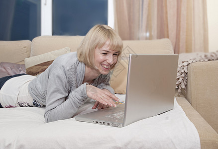 女人在沙发上用笔记本电脑图片