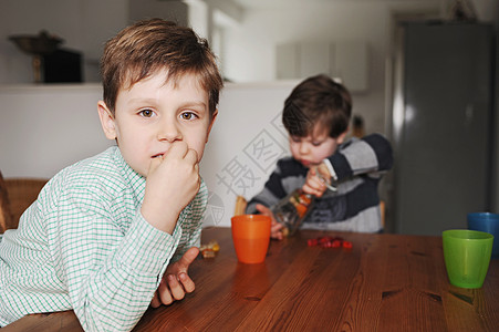 孩子吃零食男孩们在桌子上玩糖果背景