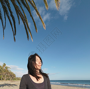 女人在沙滩上放松，闭上眼睛图片