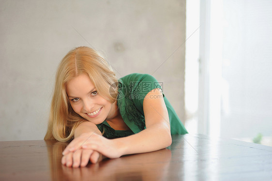 微笑的女人躺在桌子上图片