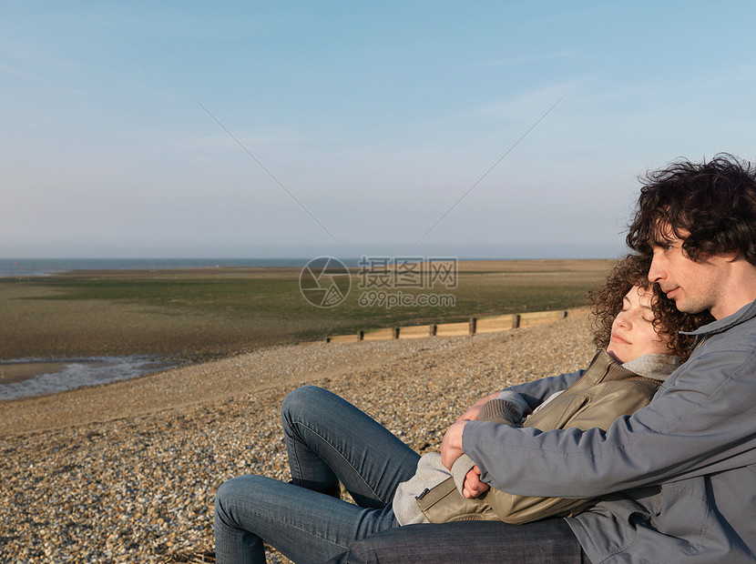 在鹅卵石滩上拥抱的一对夫妇图片