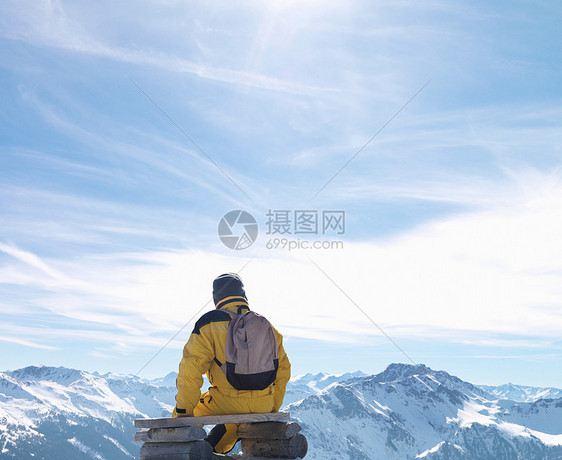 男人坐在山顶长椅上图片