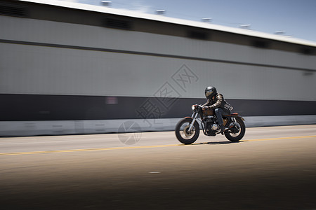 超速行驶的男性摩托车手模糊图像背景图片