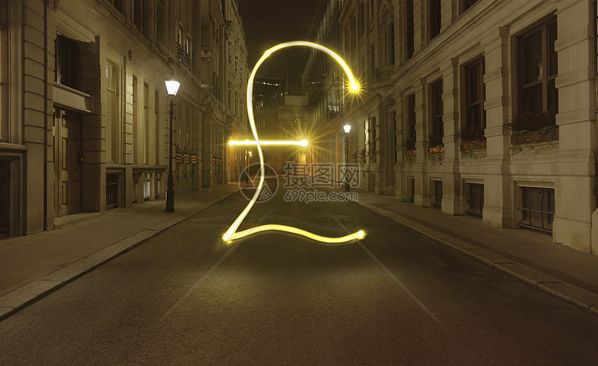 英国伦敦下夜幕中城市街道上闪亮的英镑符号图片