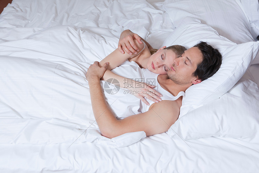 一对夫妇躺在床上拥抱着睡着了