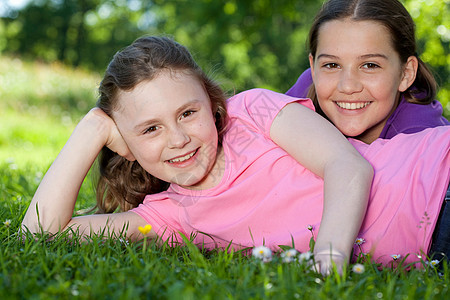 两个女孩在草地上休息白天高清图片素材
