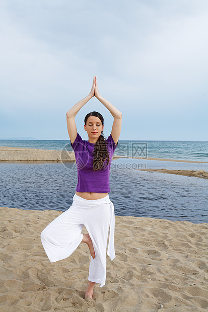 在海滩上做瑜伽的女人图片