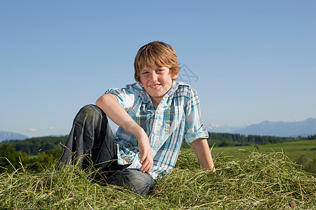 男孩坐在草地上图片