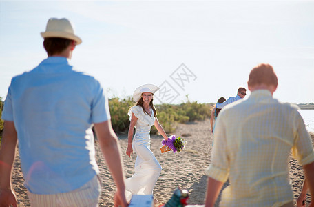 新娘和朋友在海滩上散步图片