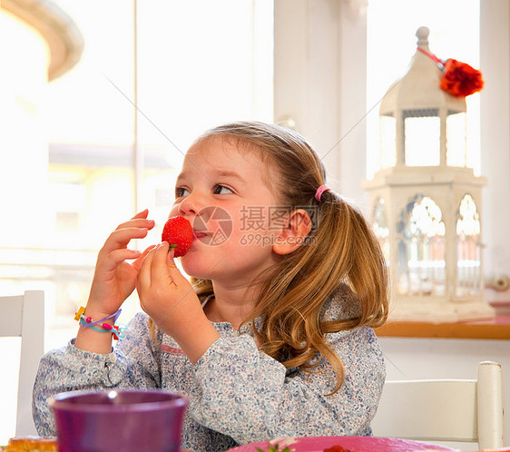 女孩在餐桌上吃草莓图片