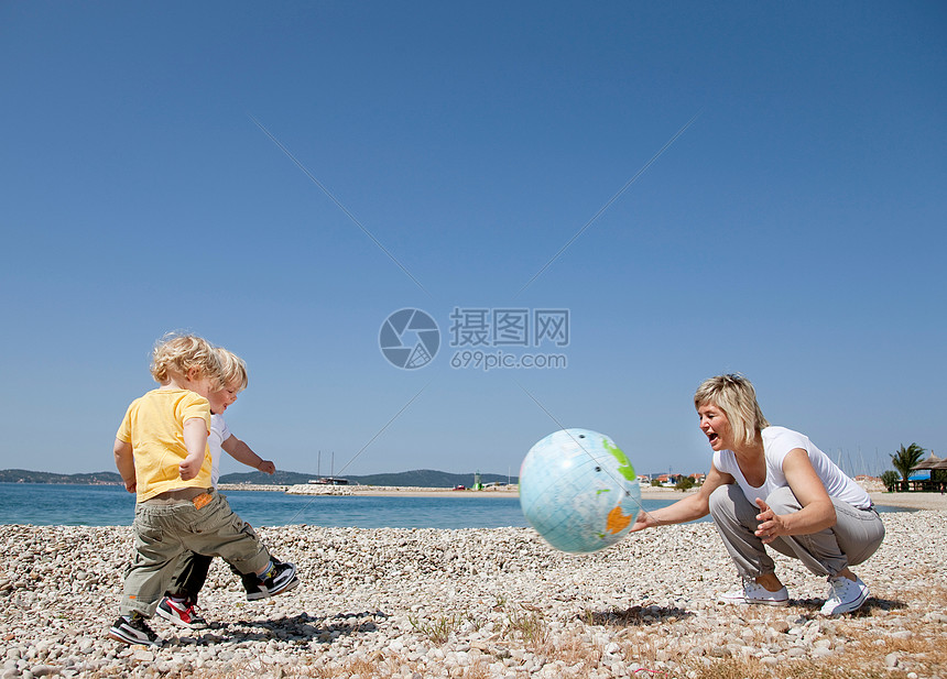 妈妈和孩子在沙滩上打球图片