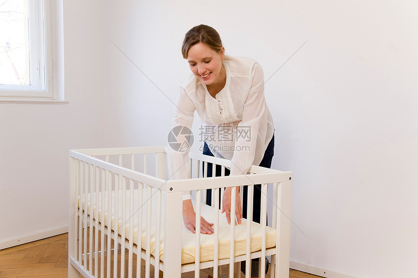 孕妇整理婴儿床图片